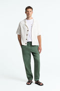 Model trägt Martin von Kings Of Indigo in Mulled Basil – entspannte Sommerhose mit elastischem Bund