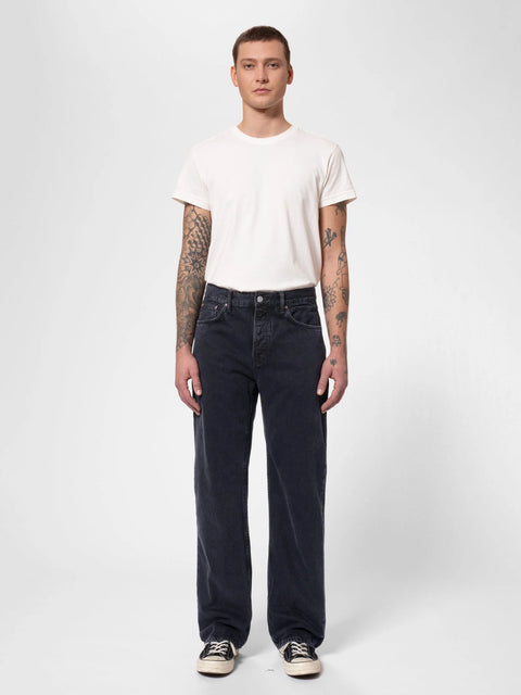 Model trägt Tuff Tony von Nudie Jeans in Black Vintage – Jeans mit entspannter Passform und mittelhohem Bund